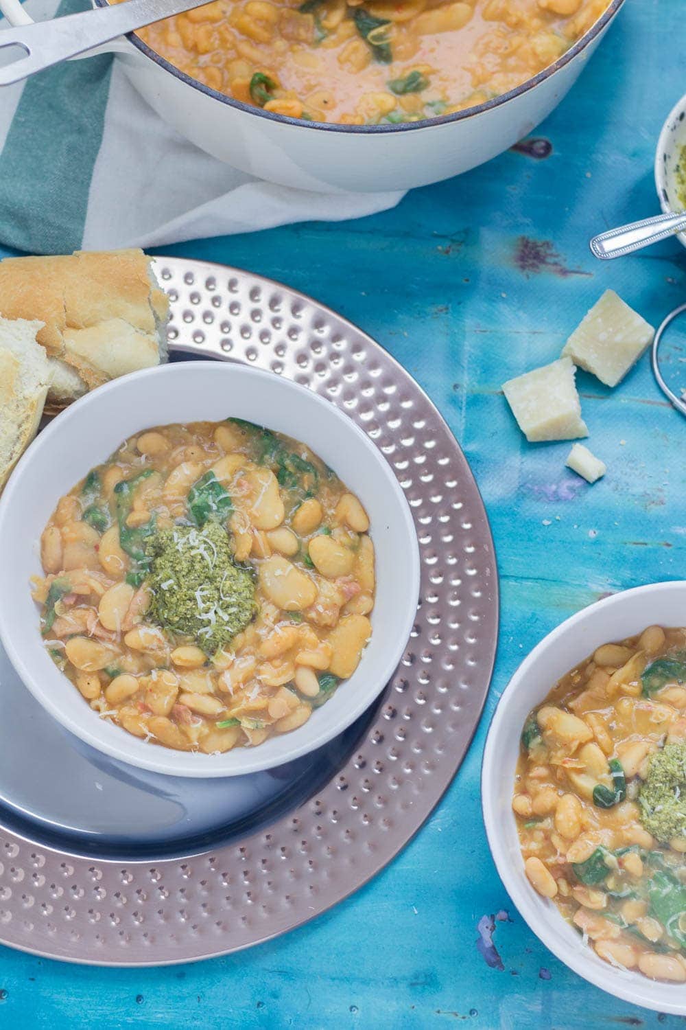 Beans are cooked with bacon, garlic & chicken stock to make this tasty white bean stew. Topped with a homemade pesto for a comforting winter dinner. 