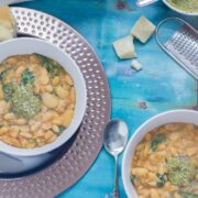 Beans are cooked with bacon, garlic & chicken stock to make this tasty white bean stew. Topped with a homemade pesto for a comforting winter dinner.