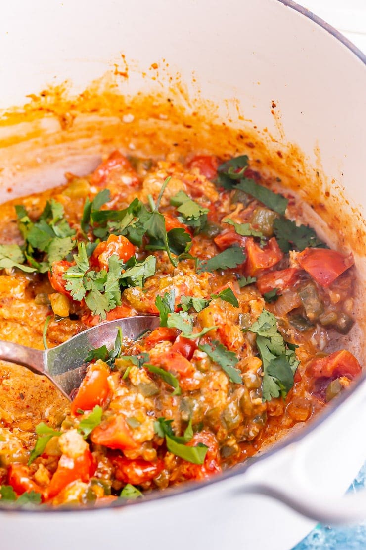 Menemen in a white pot with a spoon