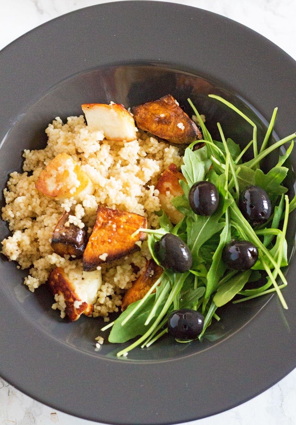 This vibrant halloumi, sweet potato and bulgur wheat salad is full of saltiness from the halloumi and olives and creamy sweetness from the sweet potato.