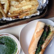 For this chimichurri steak sandwich the steak is sliced and served with caramelised onions, spinach leaves and a chimichurri dressing.