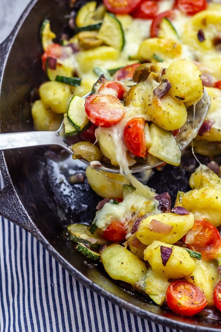 Summer gnocchi skillet with a spoon taking a portion