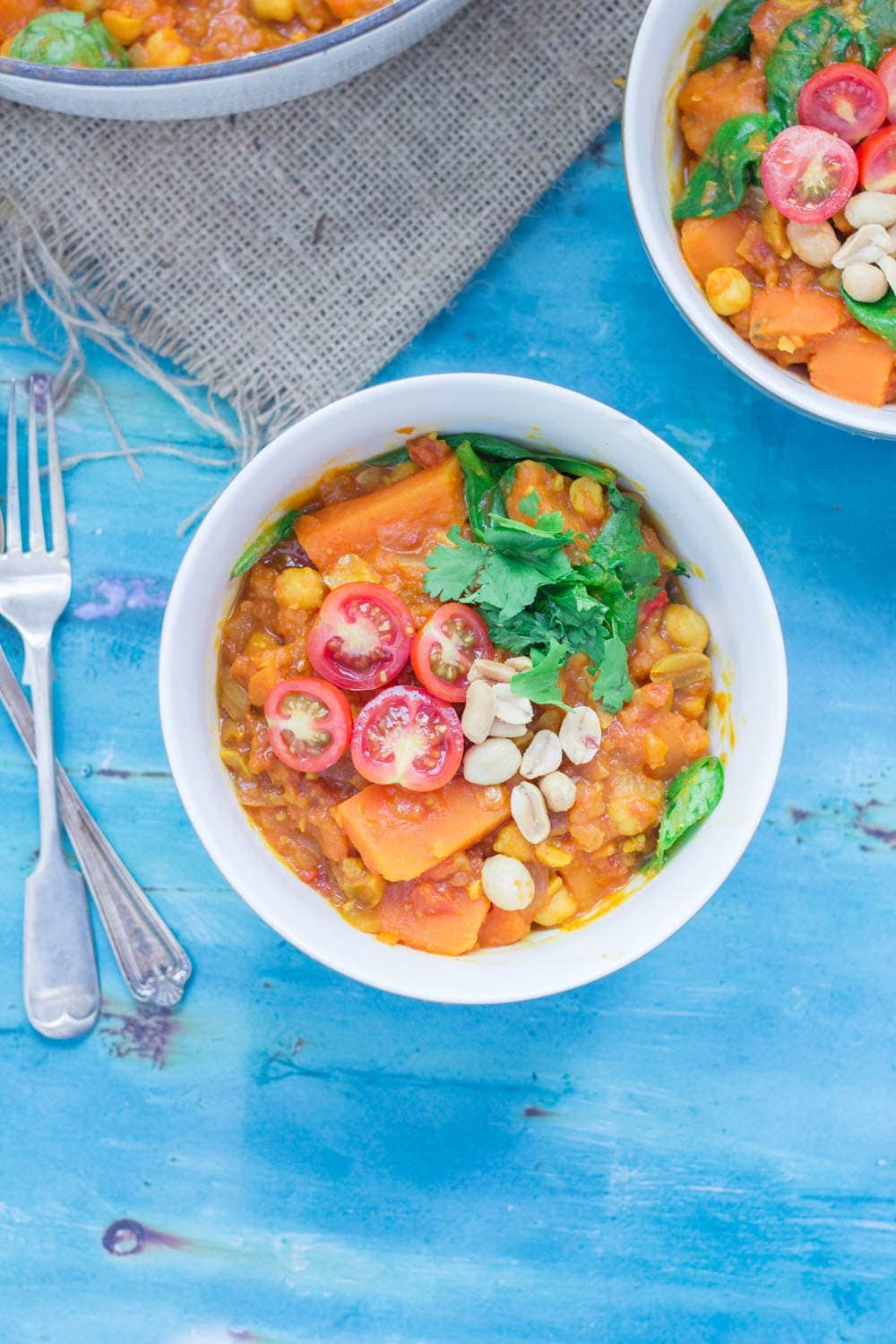 Overhead shot of peanut and sweet potato stew on a blue background