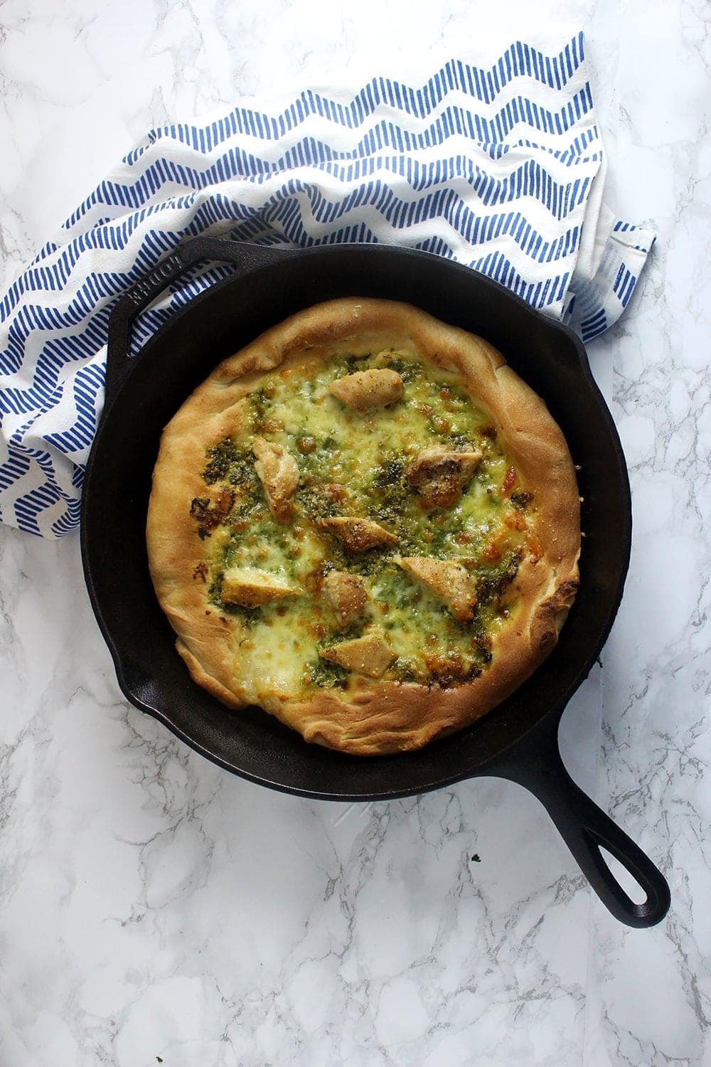 This rocket pesto chicken skillet pizza is a brilliant variation on a classic pizza. With a pesto base and a layer of mozzarella surrounding bits of chicken