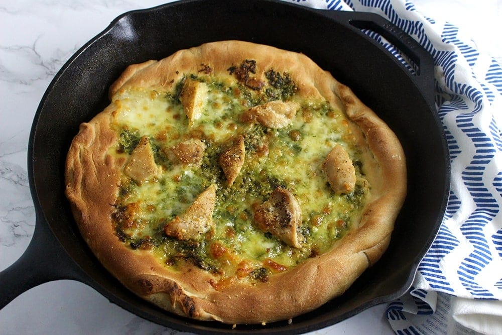This rocket pesto chicken skillet pizza is a brilliant variation on a classic pizza. With a pesto base and a layer of mozzarella surrounding bits of chicken