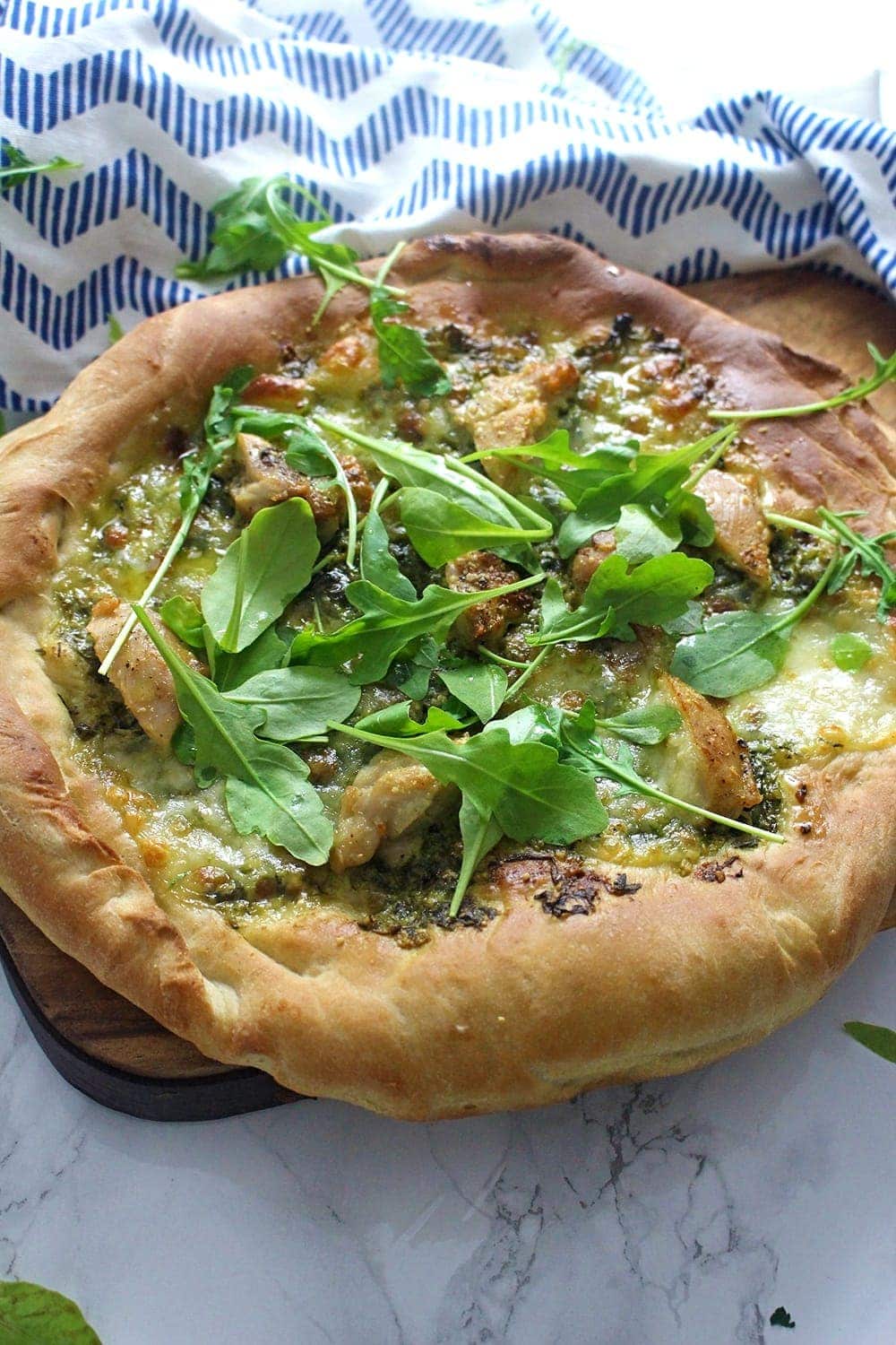 This rocket pesto chicken skillet pizza is a brilliant variation on a classic pizza. With a pesto base and a layer of mozzarella surrounding bits of chicken