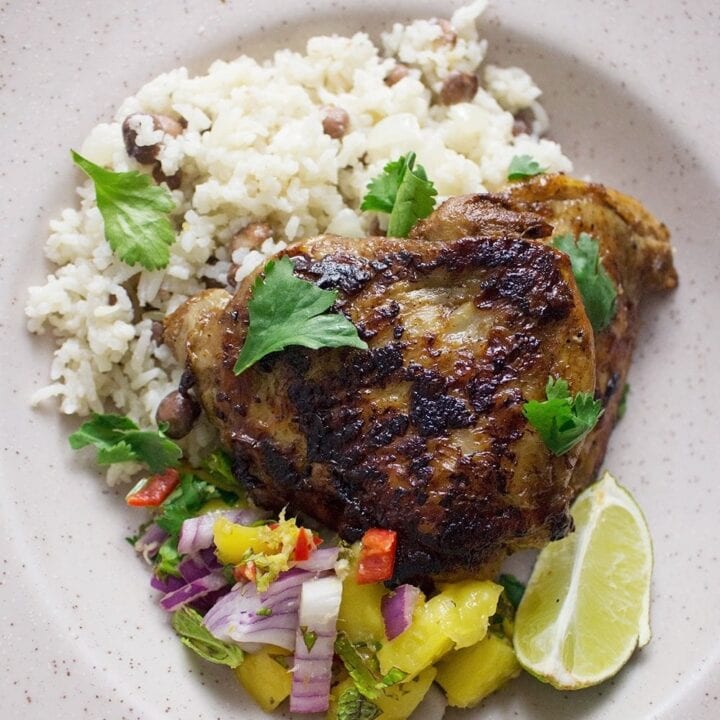 This jerk chicken is sweet and spicy, it tastes amazing served with a mango salsa and turmeric roti. Rice & peas is the perfect base for all this deliciousness!