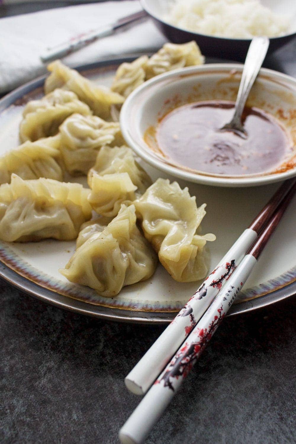 These pork potstickers with a chilli dipping sauce are filling, tasty, & easier than you think! Use premade dumpling wrappers to be ready in under an hour.