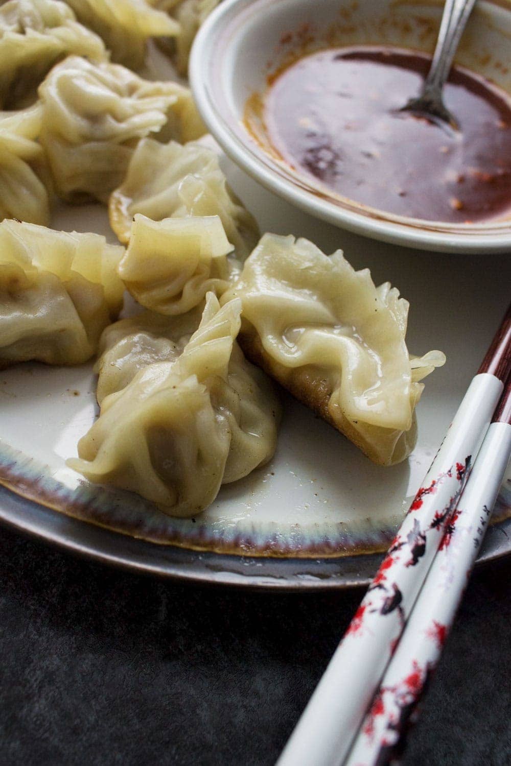 These pork potstickers with a chilli dipping sauce are filling, tasty, & easier than you think! Use premade dumpling wrappers to be ready in under an hour.