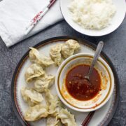 These pork potstickers with a chilli dipping sauce are filling, tasty, & easier than you think! Use premade dumpling wrappers to be ready in under an hour.