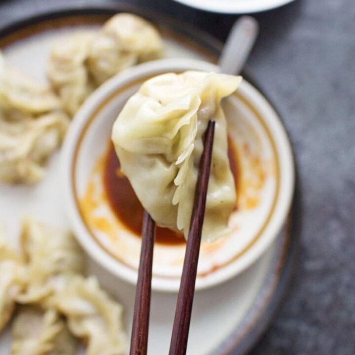 These pork potstickers with a chilli dipping sauce are filling, tasty, & easier than you think! Use premade dumpling wrappers to be ready in under an hour.