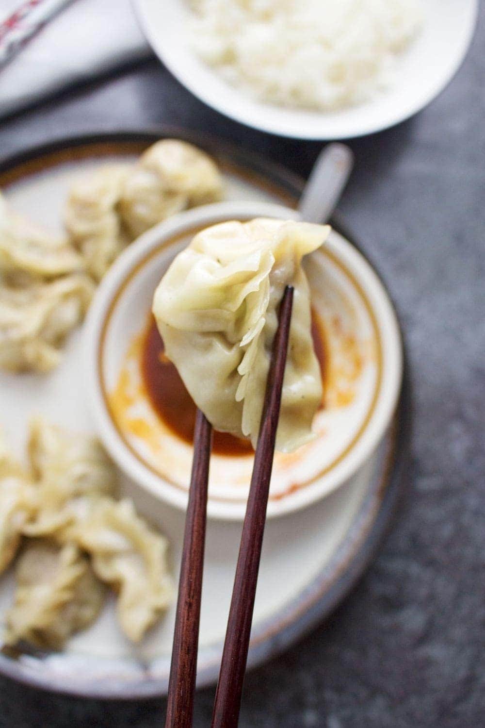 These pork potstickers with a chilli dipping sauce are filling, tasty, & easier than you think! Use premade dumpling wrappers to be ready in under an hour.