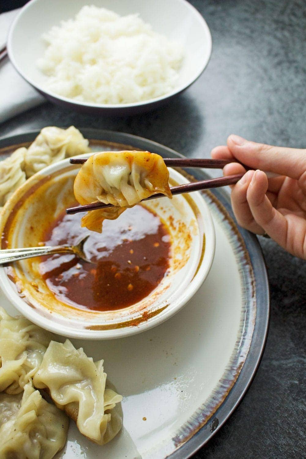 These pork potstickers with a chilli dipping sauce are filling, tasty, & easier than you think! Use premade dumpling wrappers to be ready in under an hour.