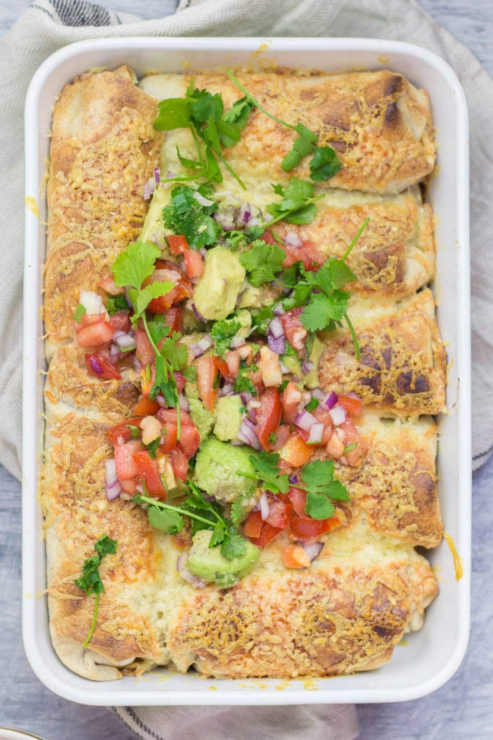 Baking dish of beef enchiladas on a cloth