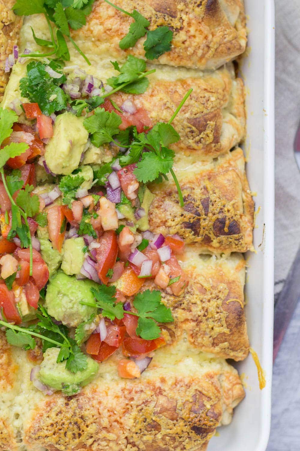 Overhead shot of beef enchiladas topped with salsa