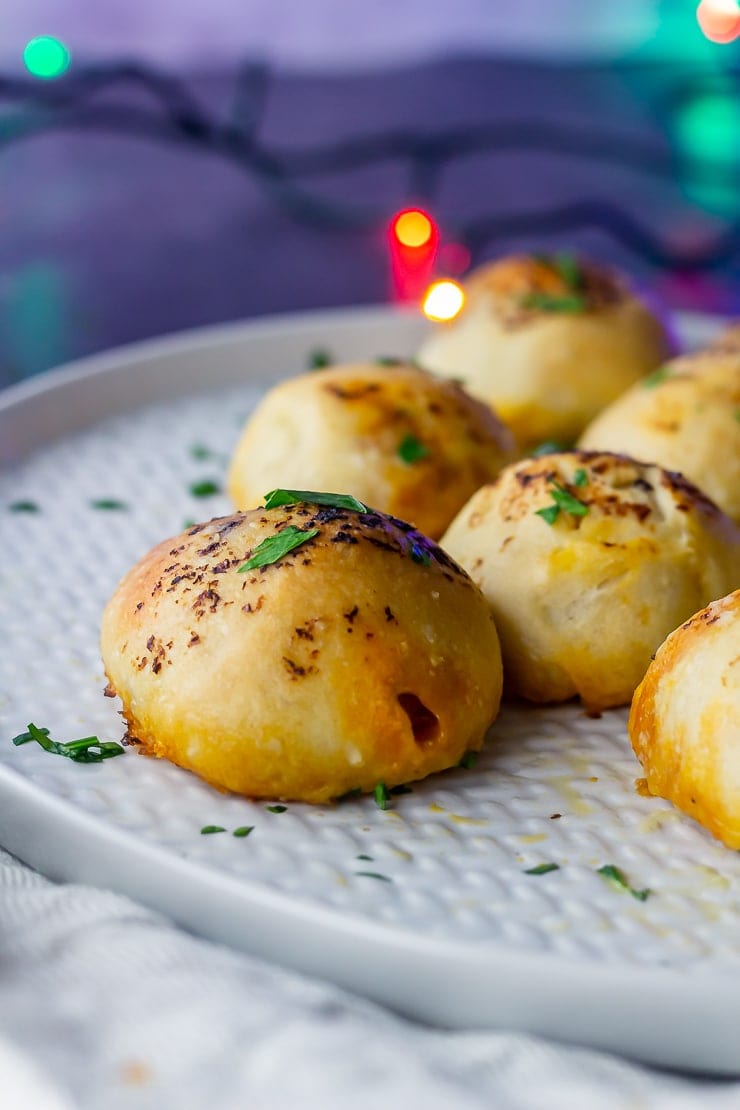 Side on shot of pesto mozzarella stuffed dough balls on a grey plate