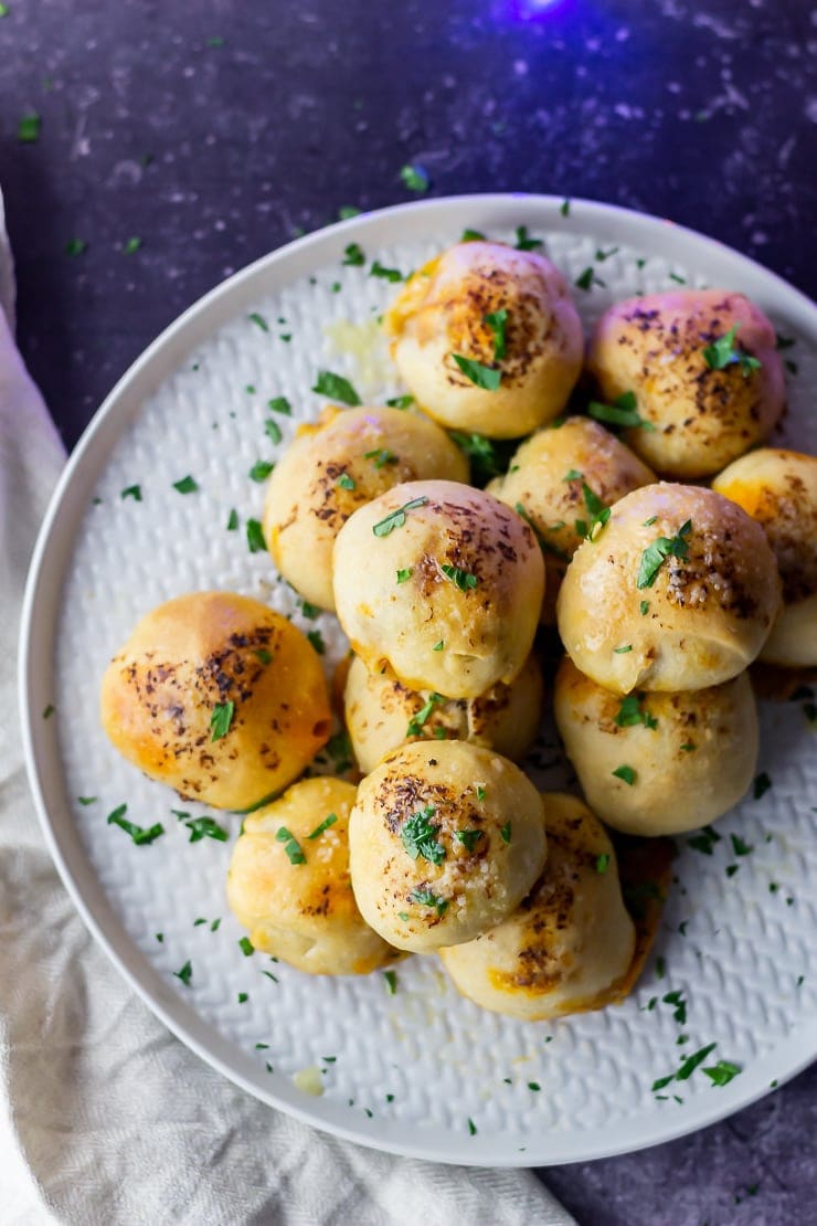 Overhead shot of pesto mozzarella stuffed dough balls on a grey plate