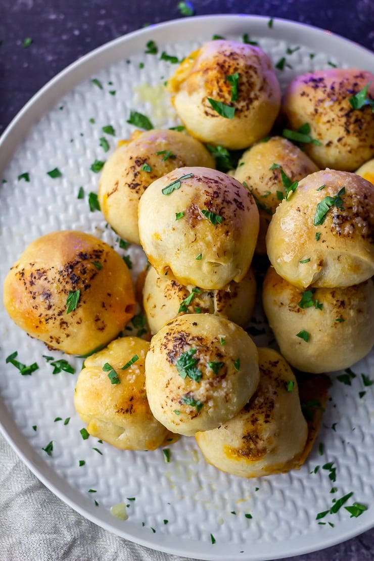 Close overhead shot of pesto mozzarella stuffed dough balls on a grey plate