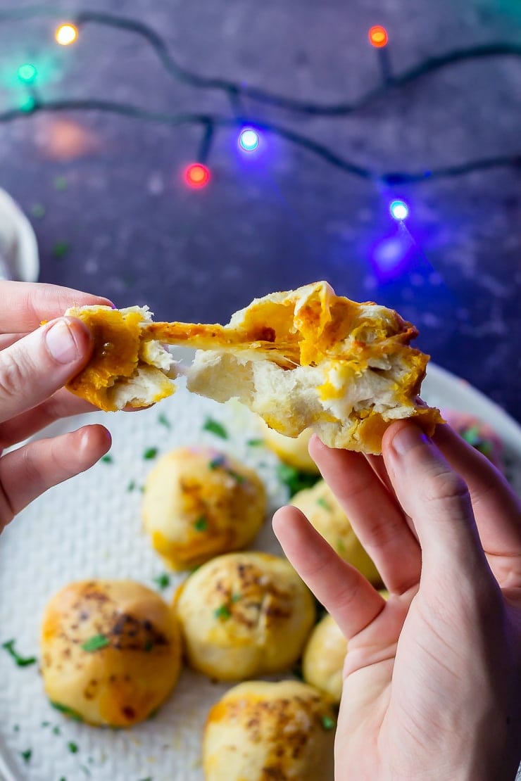 Hands holding a stuffed dough ball 