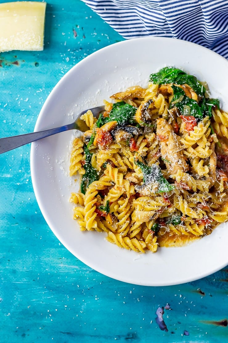 Overhead shot of one pot pasta in a white bowl on a blue background