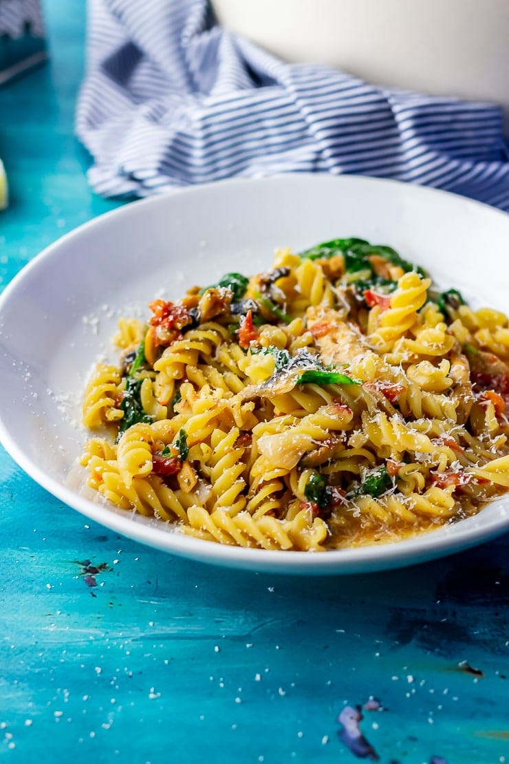 Side shot of one pot pasta with a striped cloth in the background