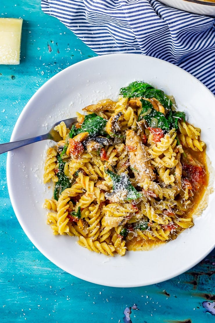 Overhead shot of one pot pasta in a white bowl on a blue background