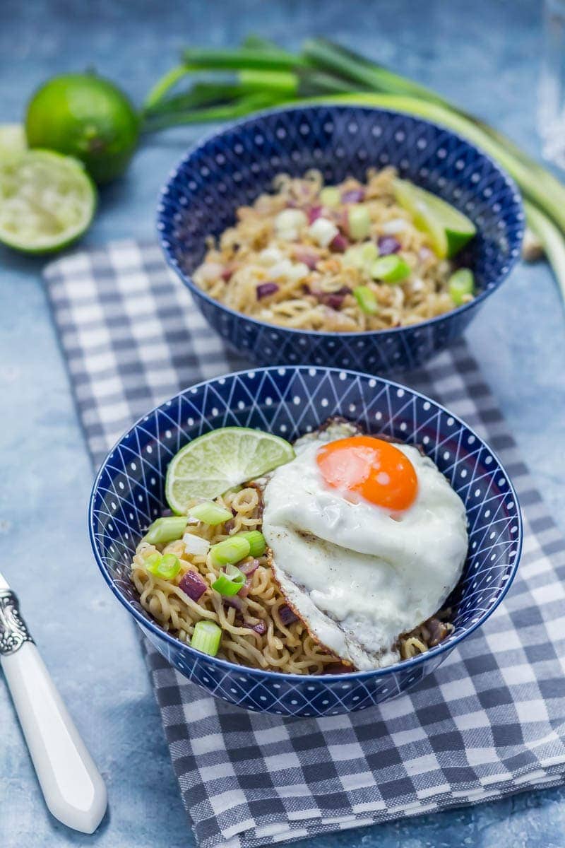 Blue bowls of soy peanut noodles on a checked cloth 