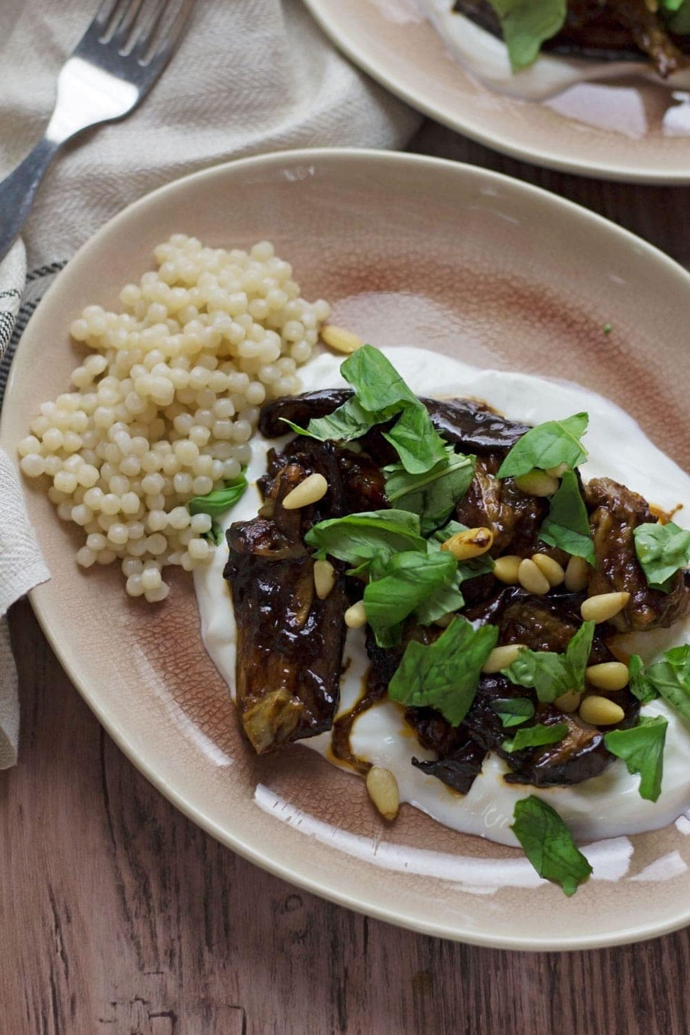 This roast aubergine gets a rich balsamic flavour from the black garlic cooled down by a bed of Greek yoghurt. Serve with Israeli couscous.