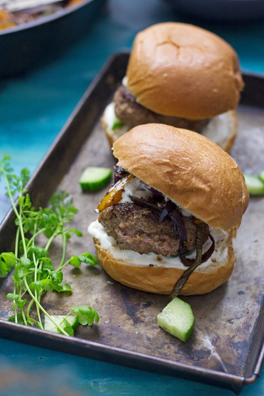 These Greek lamb burgers are served in a brioche bun. Topped with caramelised pepper and onion, refreshing cucumber and a drizzle of garlicky Greek yoghurt!