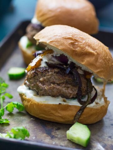 These Greek lamb burgers are served in a brioche bun. Topped with caramelised pepper and onion, refreshing cucumber and a drizzle of garlicky Greek yoghurt!