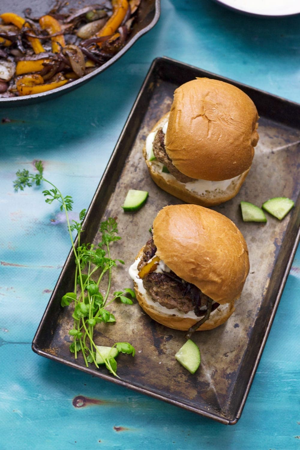 These Greek lamb burgers are served in a brioche bun. Topped with caramelised pepper and onion, refreshing cucumber and a drizzle of garlicky Greek yoghurt!