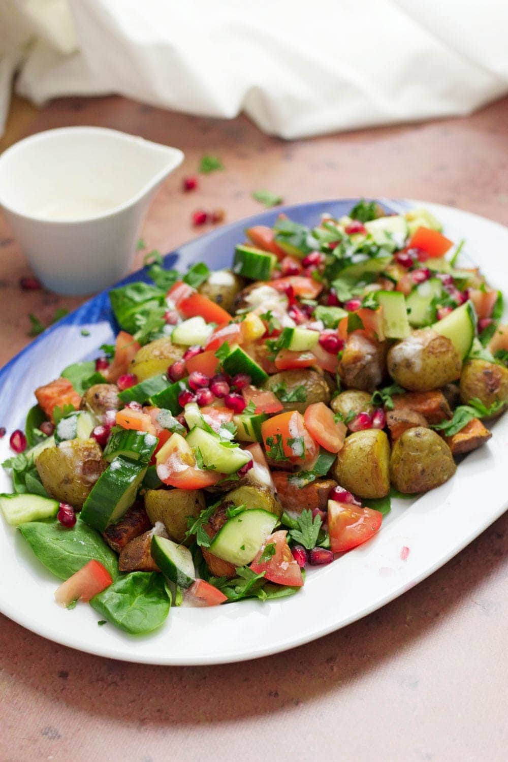 Photo of potato salad recipe on a brown surface with a white jug