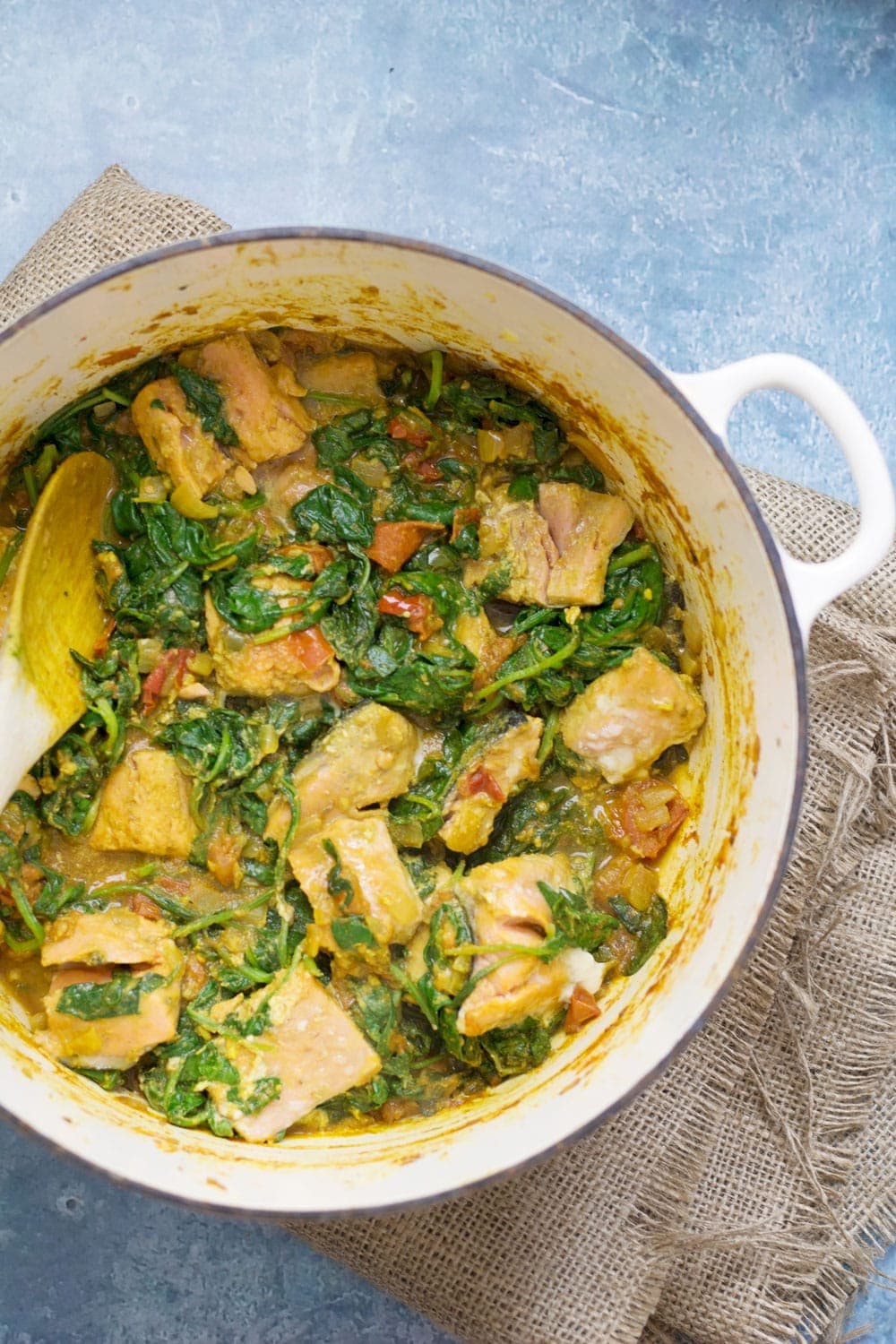 Overhead shot of healthy salmon curry on a blue background