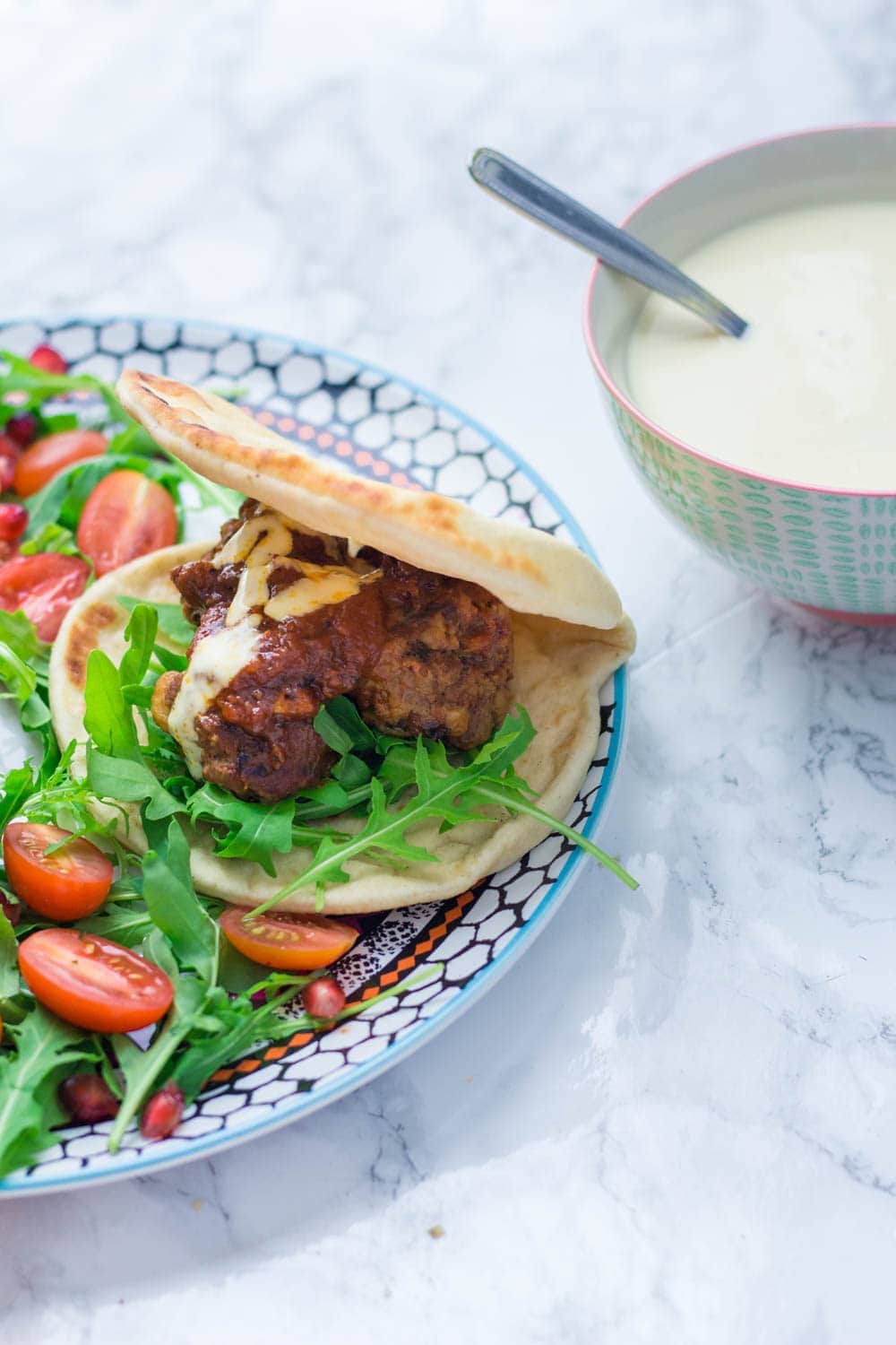 These Moroccan meatball flatbreads are surprisingly quick to make. The meatballs are simmered in a harissa tomato sauce and served with a drizzle of aioli.