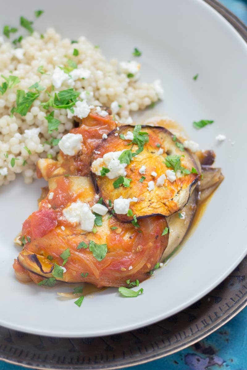 Close up of baked aubergine with cous cous in a grey bowl
