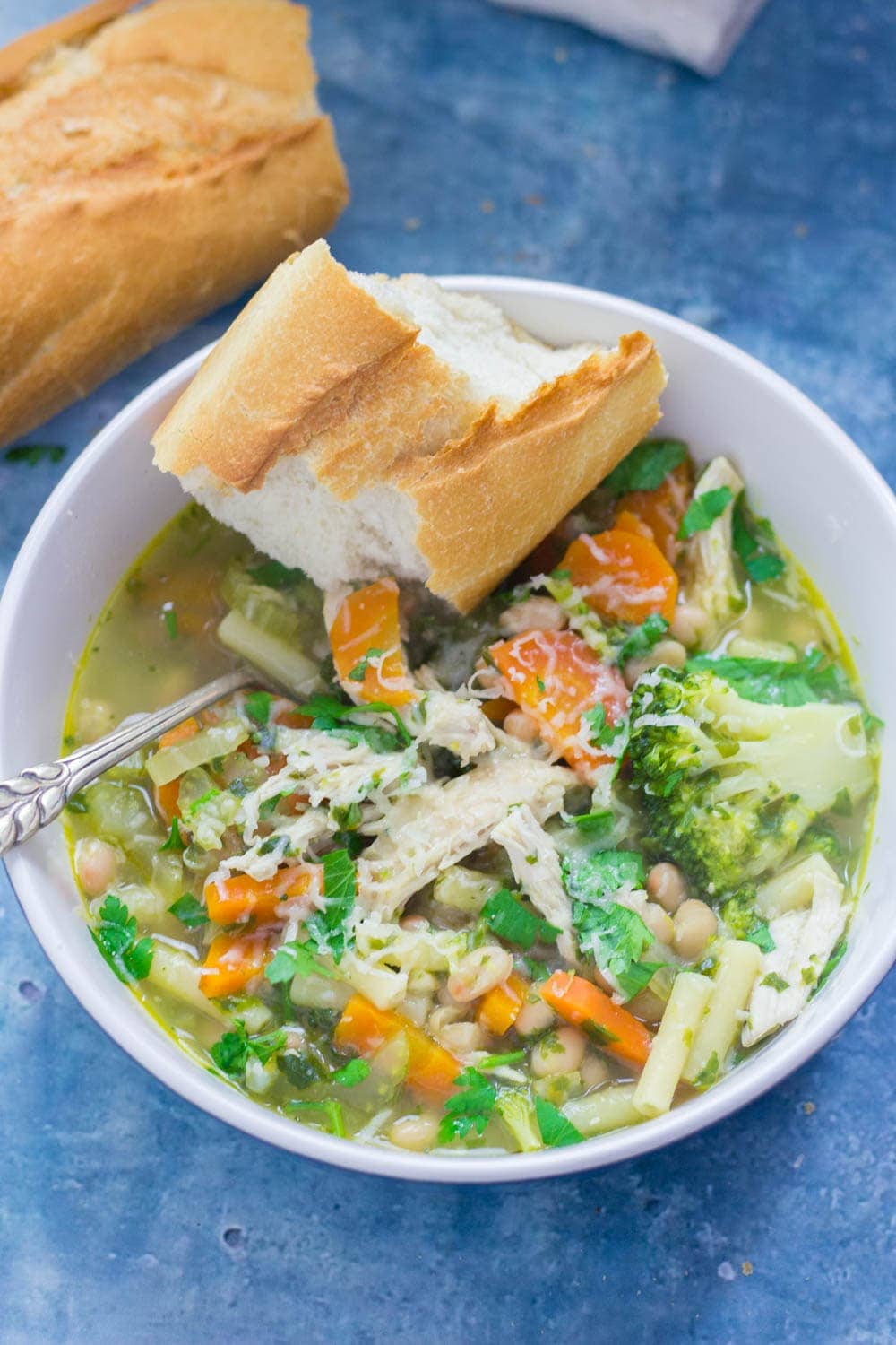 Bowl of soup topped with parmesan and bread