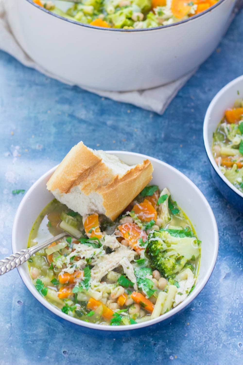 Bowl of soup on a blue background with bread