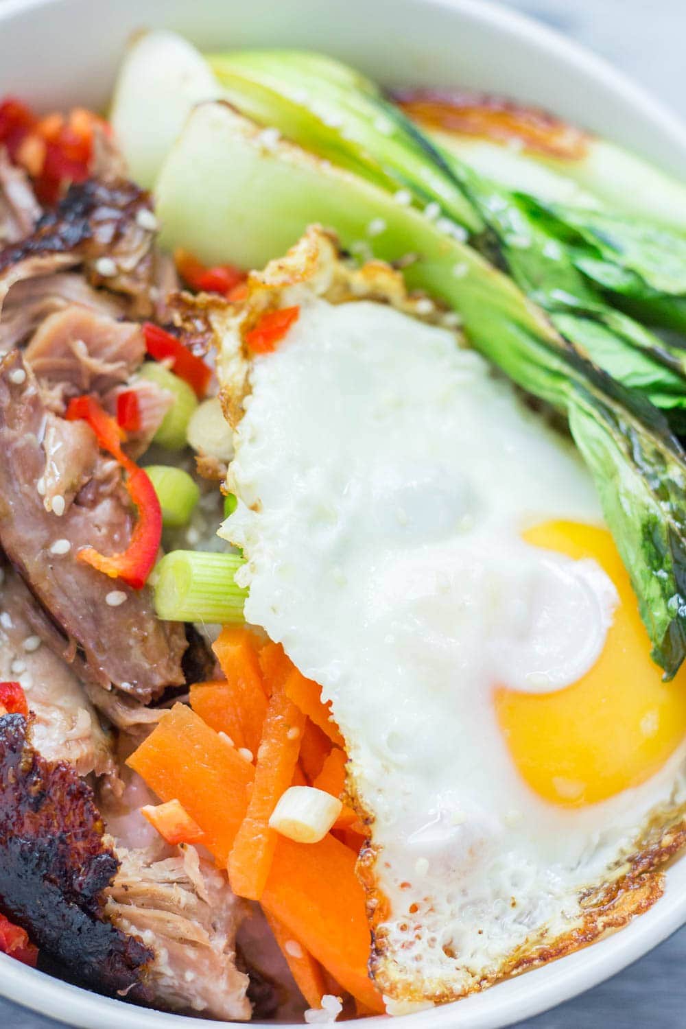 Japanese roast duck legs are shredded and served over sticky rice with pak choi, chilli and perfectly soft fried egg for a tasty dinner all in one bowl! #japanese #duck #roastduck #recipe #healthyrecipe