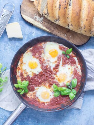 Serve up a hearty breakfast with this Italian twist on a shakshuka made with a delicious oregano tomato sauce and finished with a sprinkling of parmesan. #shakshuka #recipe #breakfast #brunch #italianfood