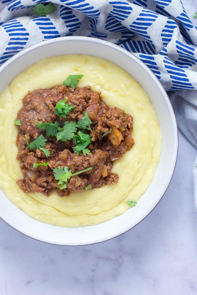 Five Ingredient Beef Ragu with Creamy Polenta. This beef ragu is the perfect quick, weeknight dinner. It takes only five ingredients to make and tastes amazing served over creamy, cheesy polenta. There's no better winter meal! #beefragu #polenta #recipe #dinner