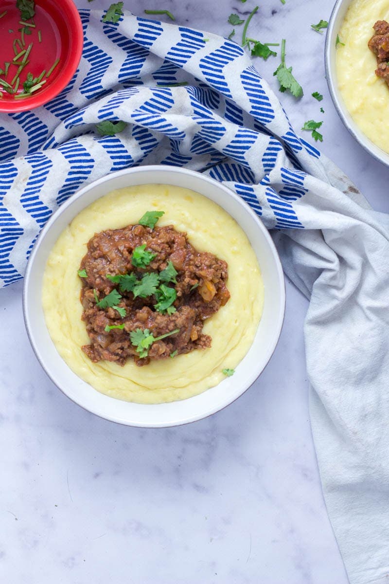 Five Ingredient Beef Ragu with Creamy Polenta. This beef ragu is the perfect quick, weeknight dinner. It takes only five ingredients to make and tastes amazing served over creamy, cheesy polenta. There's no better winter meal! #beefragu #polenta #recipe #dinner 