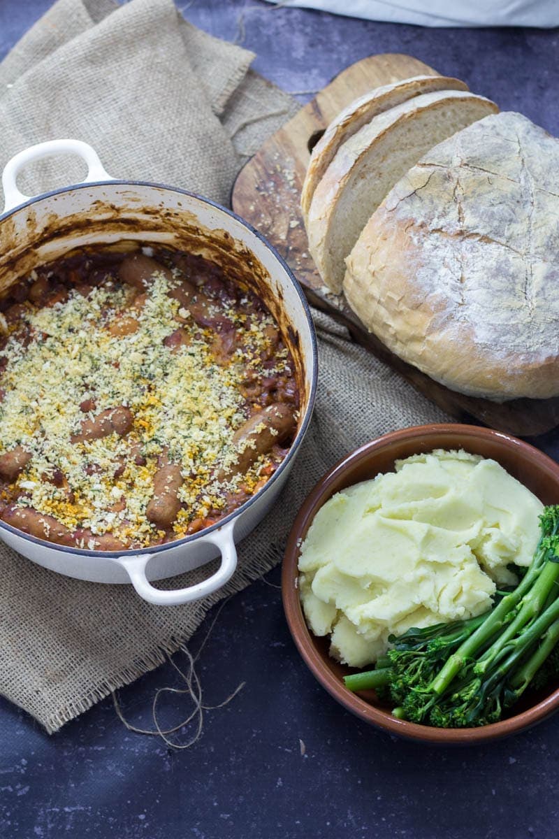 Sausage and Bean Casserole with Breadcrumb Topping. Sausage and bean casserole is perfect weekend comfort food but it works just as well served up at a dinner party! It can be made all in one pot so you can sit back and relax! #stew #sausage #beans #recipe