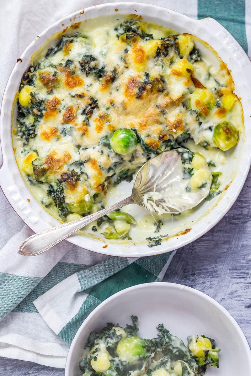 Cheesy Baked Gnocchi with Kale & Brussels Sprouts. There is nothing more comforting than this cheesy baked gnocchi. It's bulked out with kale and Brussels sprouts for a satisfying dinner which is still pretty healthy! #gnocchi #bakedgnocchi #kale #sprouts #comfortfood #recipe