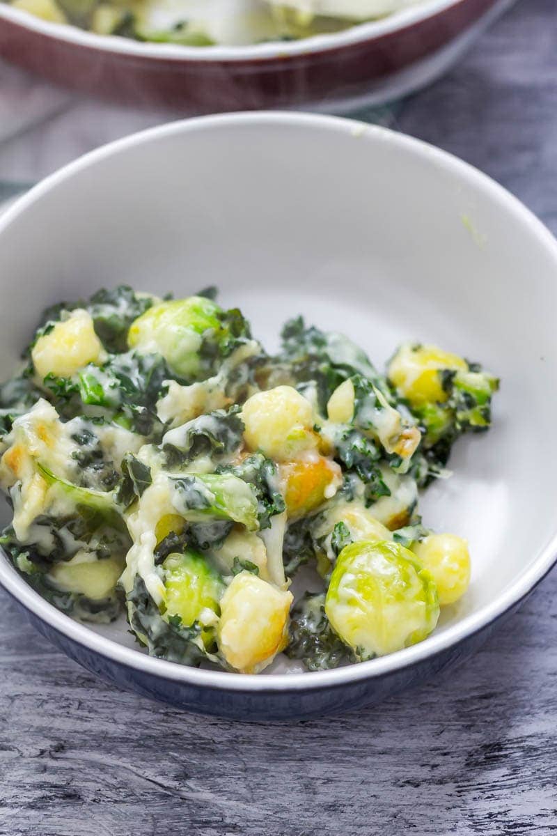 Cheesy Baked Gnocchi with Kale & Brussels Sprouts. There is nothing more comforting than this cheesy baked gnocchi. It's bulked out with kale and Brussels sprouts for a satisfying dinner which is still pretty healthy! #gnocchi #bakedgnocchi #kale #sprouts #comfortfood #recipe