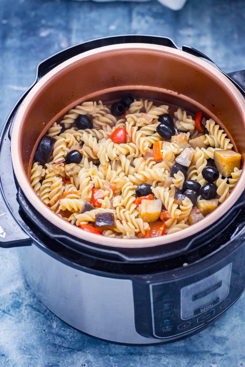 Pressure cooker pasta in a pressure cooker with olives, peppers, aubergine and red onion