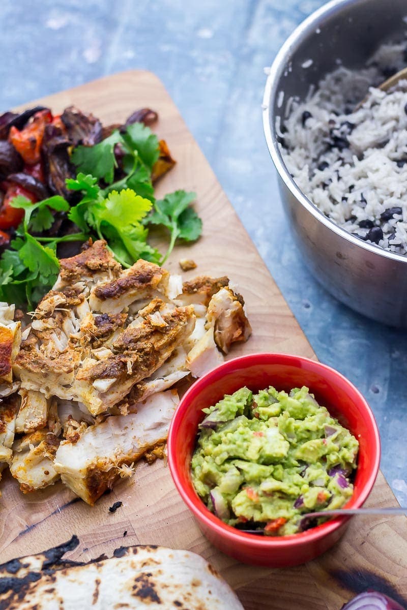 Fish, vegetables and guacamole on a wooden board 