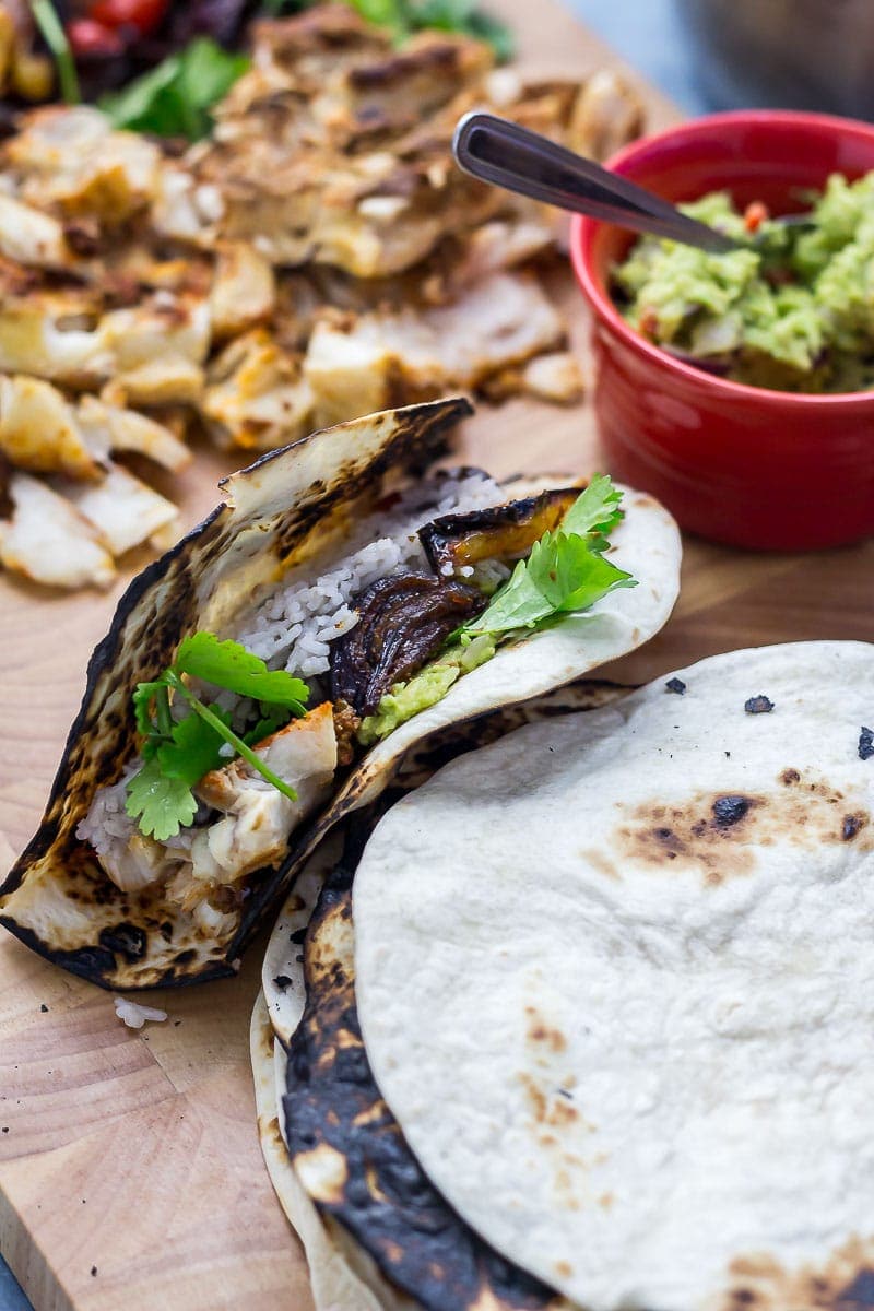 Fish taco and tortillas on a wooden board 