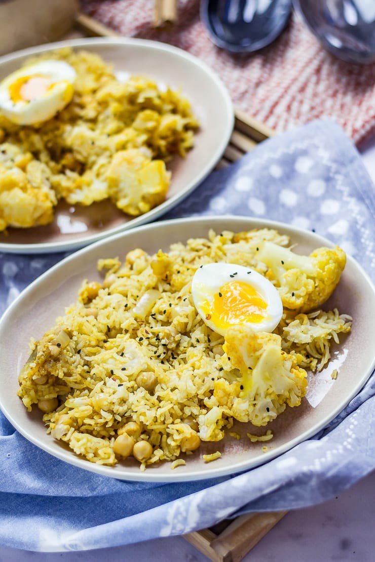 Biryani with Cauliflower & Chickpeas on a plate with a spotted cloth on a wooden tray