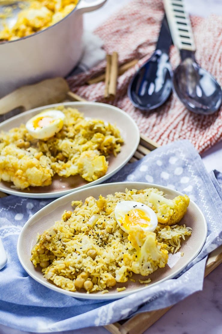 Biryani with Cauliflower & Chickpeas on a plate with a spotted cloth on a wooden tray