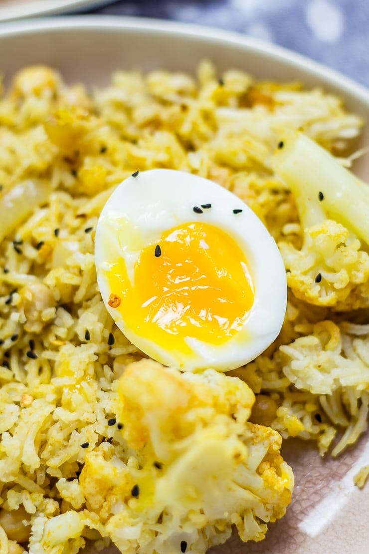Close up of a boiled egg on top of Biryani with Cauliflower & Chickpeas